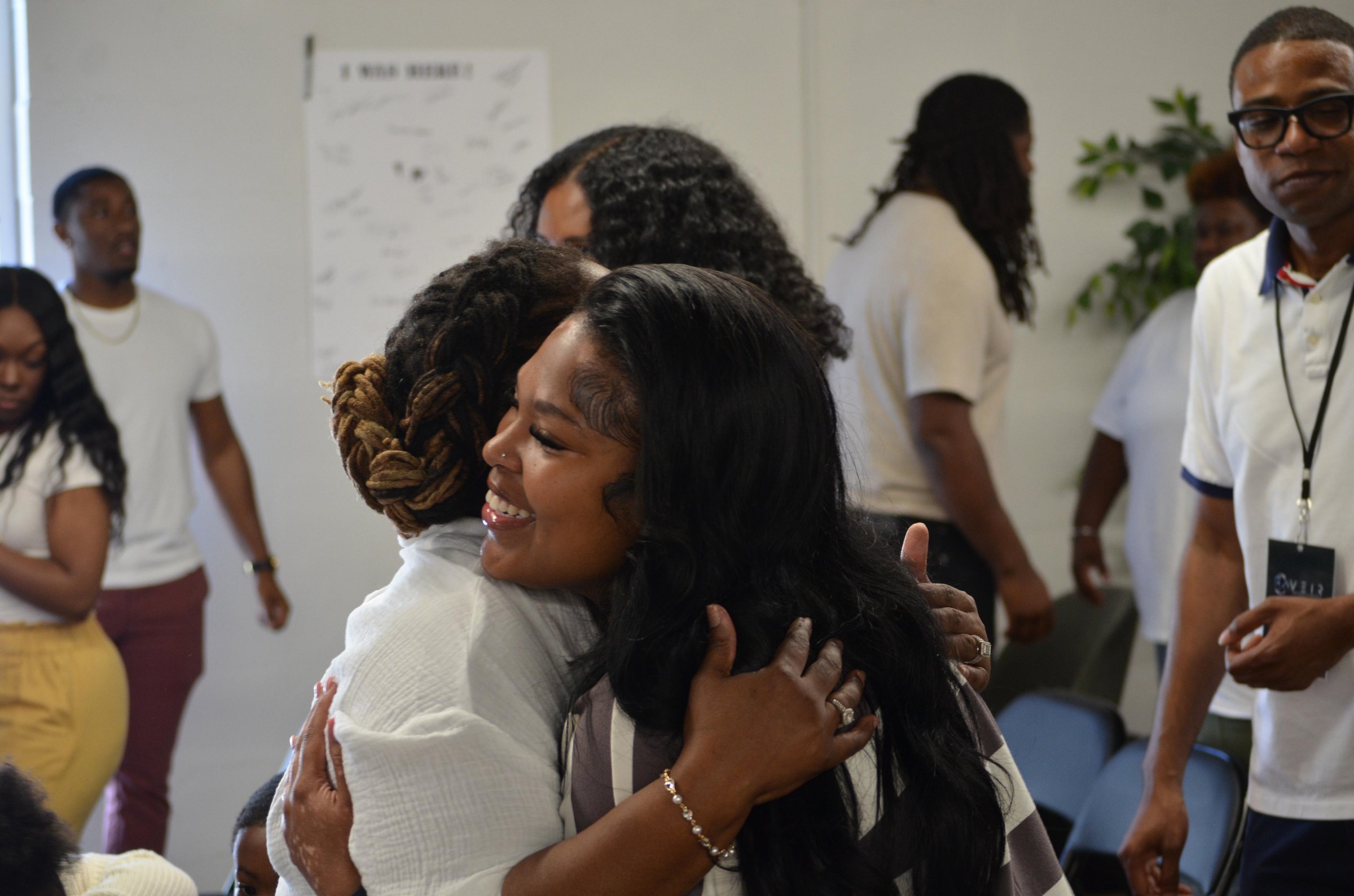 Two women embracing, one beaming at the camera